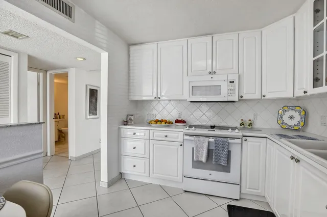 a kitchen with stainless steel appliances granite countertop a stove and white cabinets