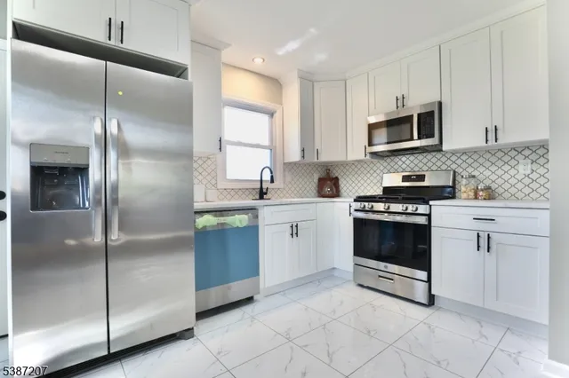 a kitchen with white cabinets and white appliances