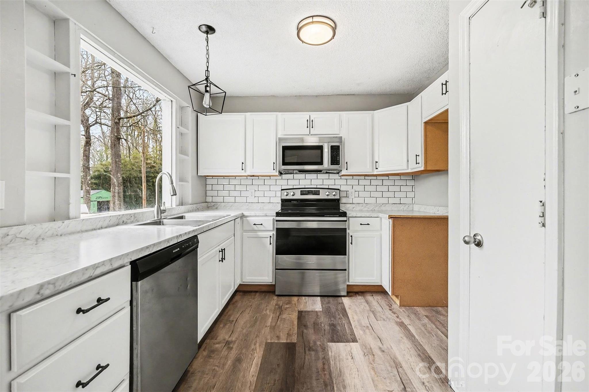 8011 Beacon Hills Road Indian Trail, NC 28079 - Photo 13 of 31 a kitchen with a sink a window and stainless steel appliances