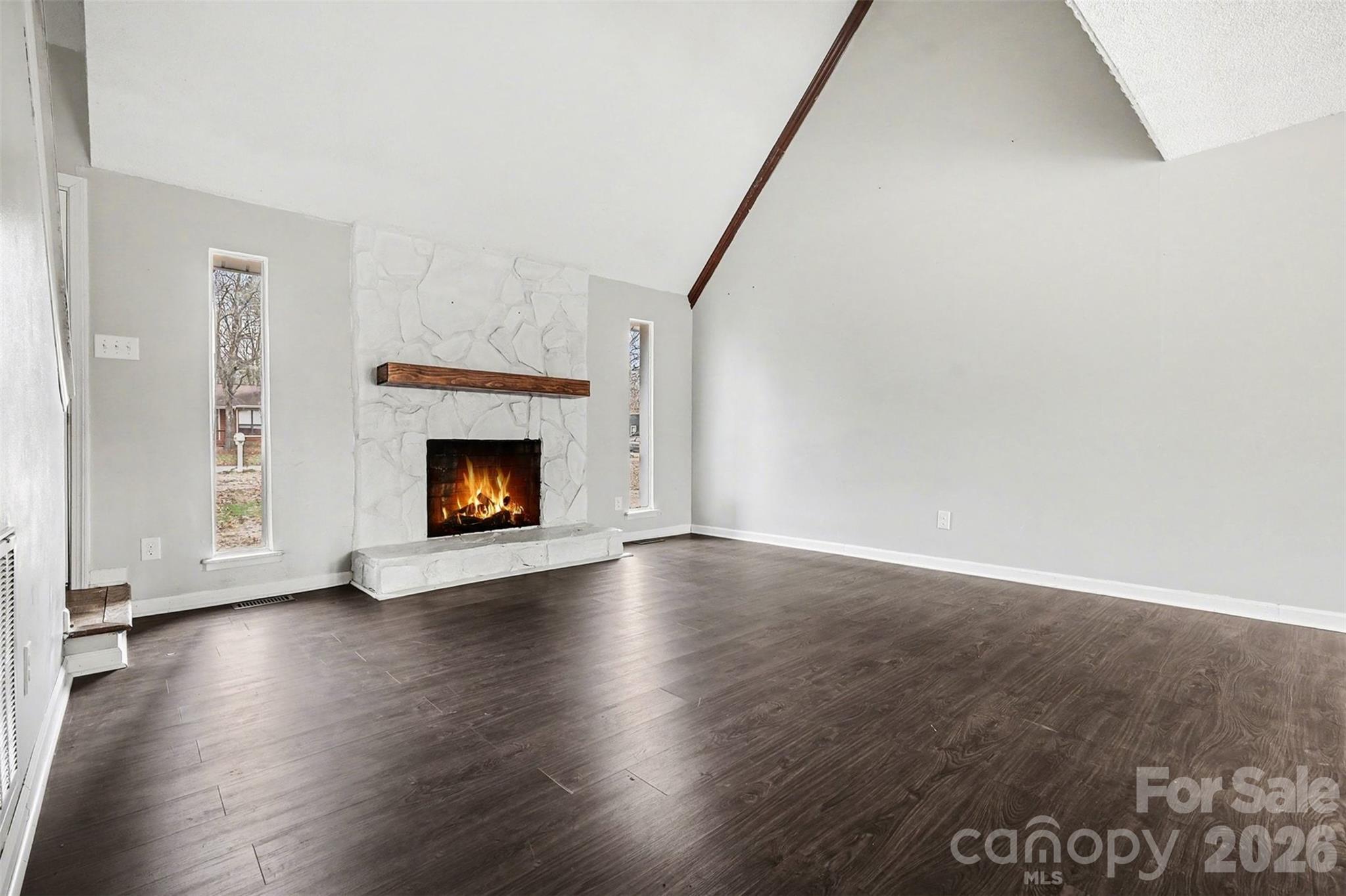 8011 Beacon Hills Road Indian Trail, NC 28079 - Photo 5 of 31 a view of an empty room with wooden floor fireplace and a window