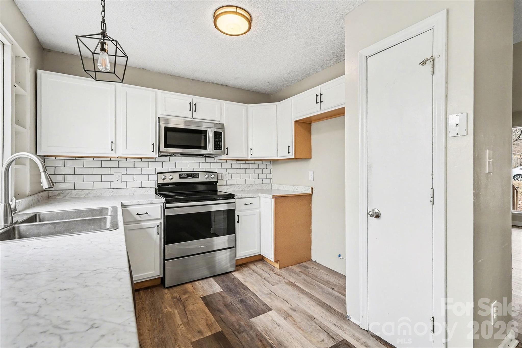 8011 Beacon Hills Road Indian Trail, NC 28079 - Photo 10 of 31 a kitchen with granite countertop a stove and a sink