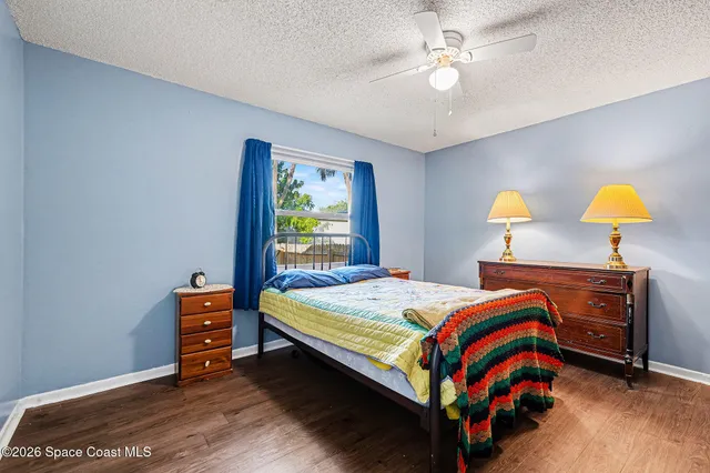 a bedroom with a large bed chandelier and a window