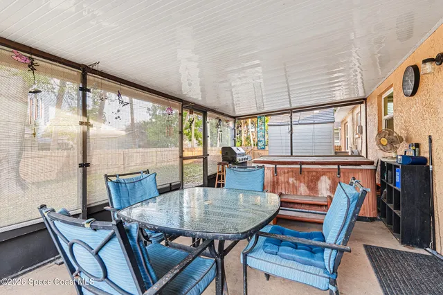 a view of a house with a small yard and a large tree