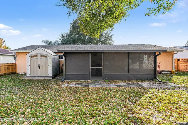 a view of a house with backyard and trees