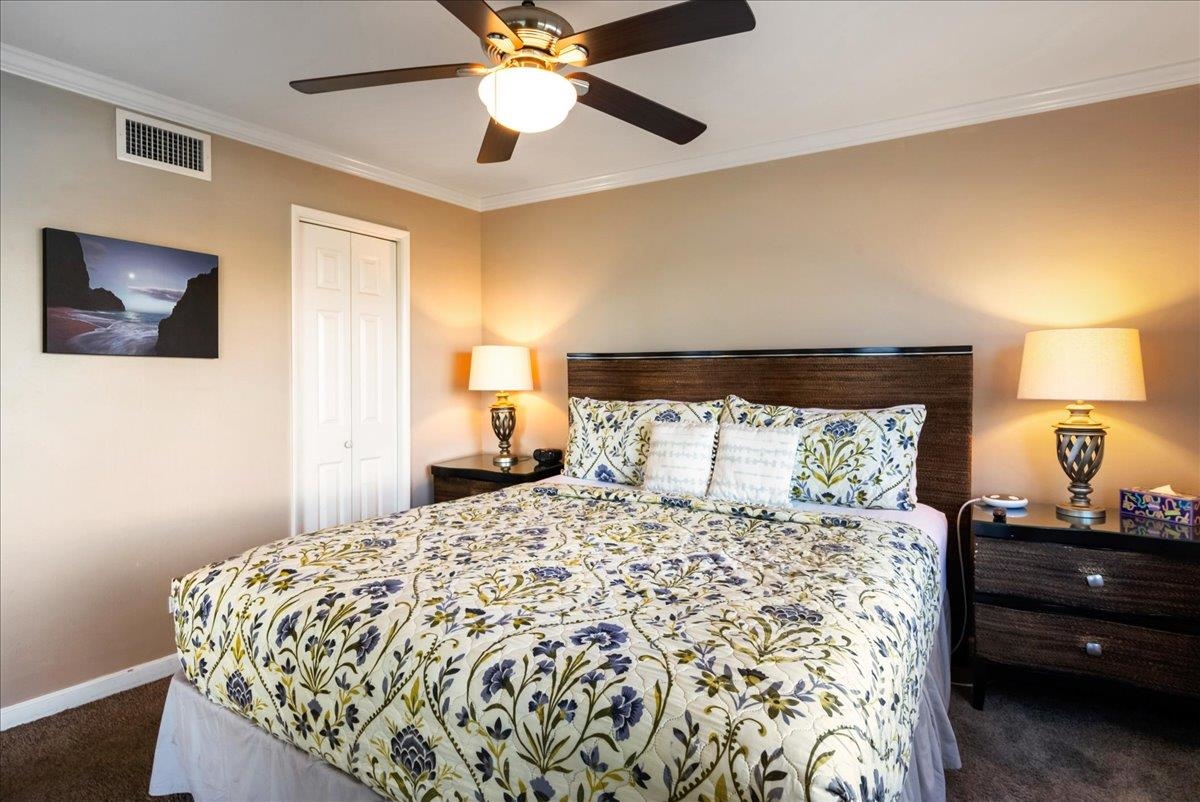 2430 South Kihei Road, Unit 206 Kihei, HI 96753 - Photo 19 of 40 a bedroom with a large bed and a lamp on dresser