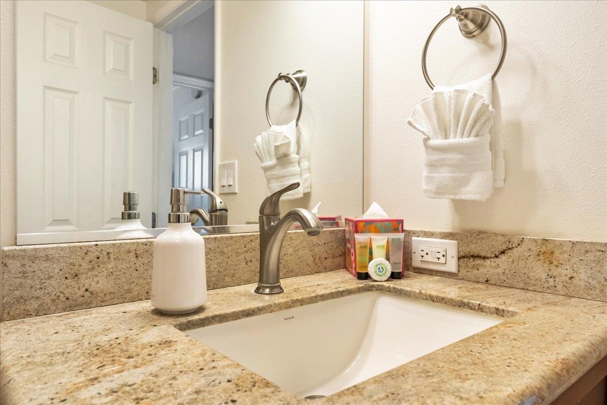 2430 South Kihei Road, Unit 206 Kihei, HI 96753 - Photo 27 of 40 a bathroom with a granite countertop sink and a mirror