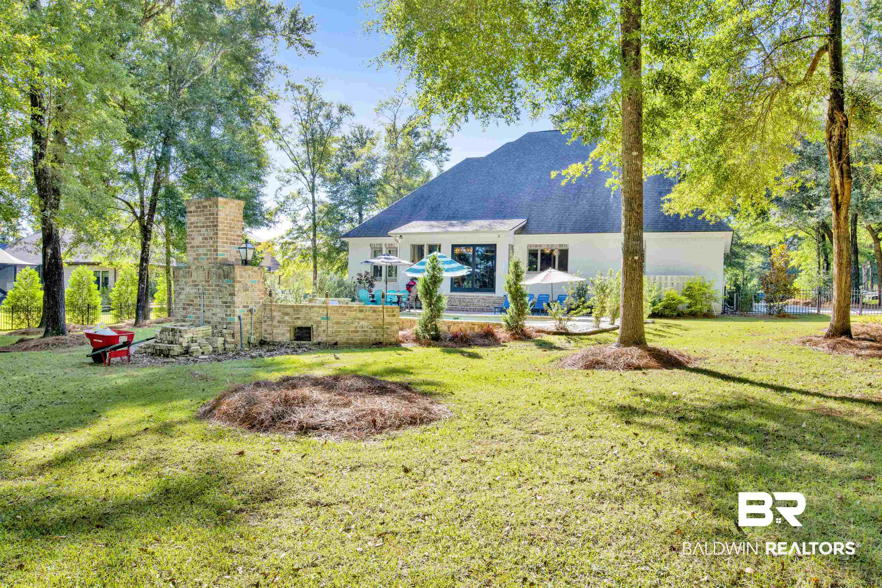 11116 Redfern Road Daphne, AL 36526 - Photo 15 of 46 Rear view of property featuring a lawn, stucco siding, and a chimney