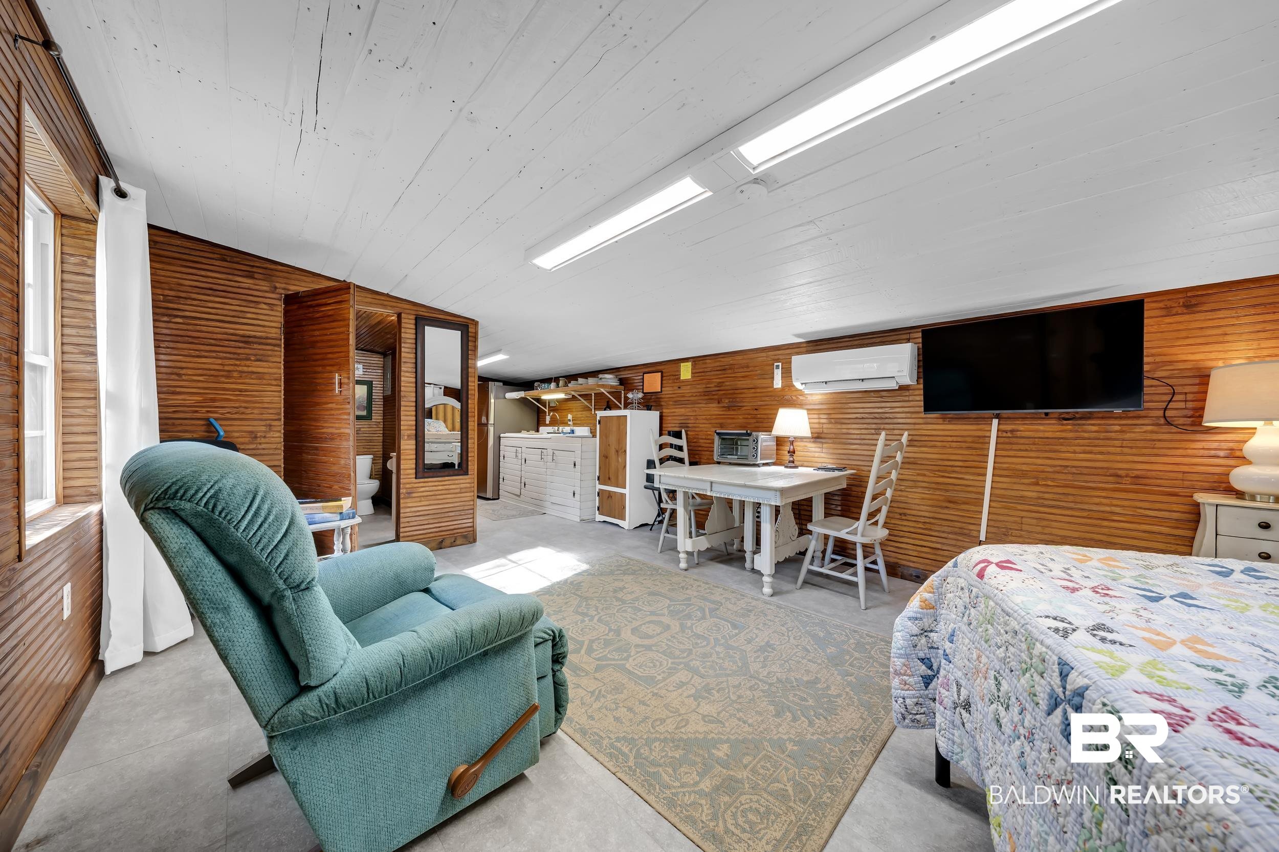 13232 Mary Ann Bch Road Fairhope, AL 36532 - Photo 46 of 79 Bedroom featuring wood walls, a wall unit AC, concrete flooring, and wooden ceiling