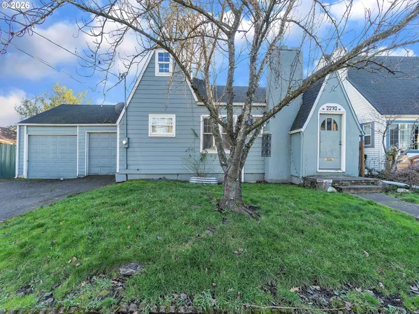 a view of a yard in front of a house with large tree