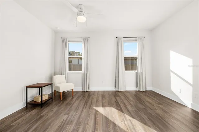 a view of a room with wooden floor lounge chair and windows