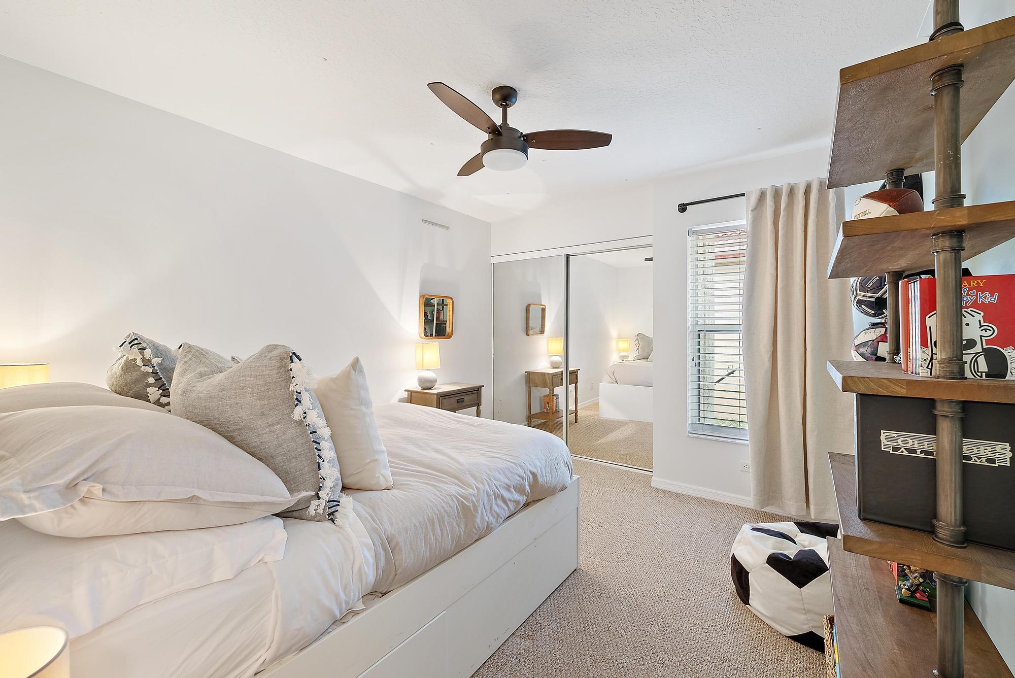 5010 Elpine Way Riviera Beach, FL 33418 - Photo 16 of 27 a bed room with a bed and a book shelf