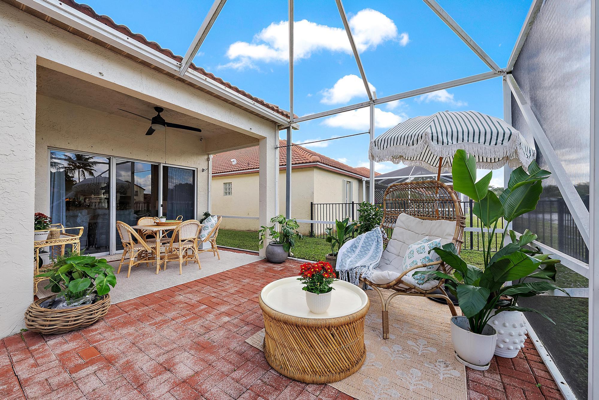 5010 Elpine Way Riviera Beach, FL 33418 - Photo 20 of 27 a view of a patio with a table and chairs and potted plants