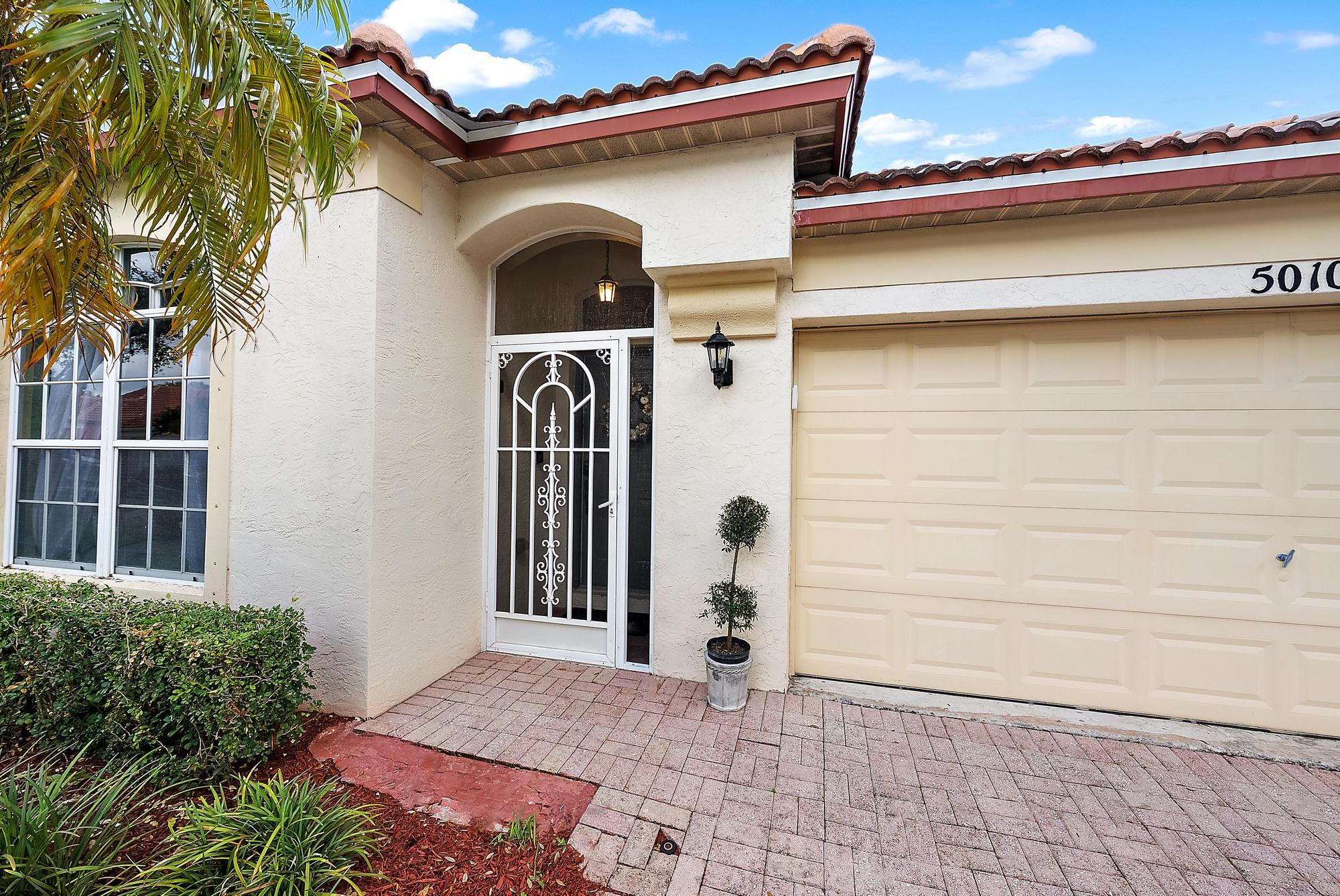 5010 Elpine Way Riviera Beach, FL 33418 - Photo 2 of 27 a front view of a house with a yard