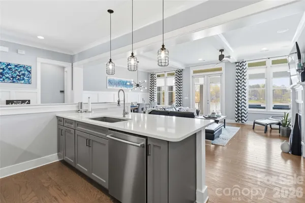 a kitchen with counter top space sink stove and wooden floor