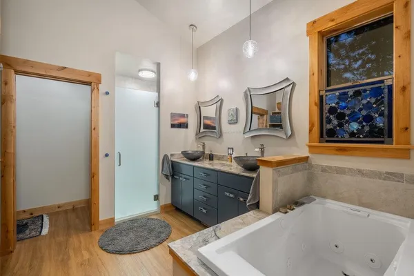 a spacious bathroom with a tub sink and mirror