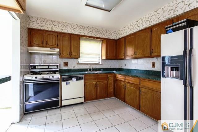7202 Hana Road Edison, NJ 08817 - Photo 12 of 25 a kitchen with stainless steel appliances granite countertop a stove a sink and a microwave