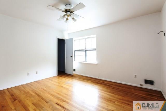7202 Hana Road Edison, NJ 08817 - Photo 7 of 25 an empty room with a window and a ceiling fan