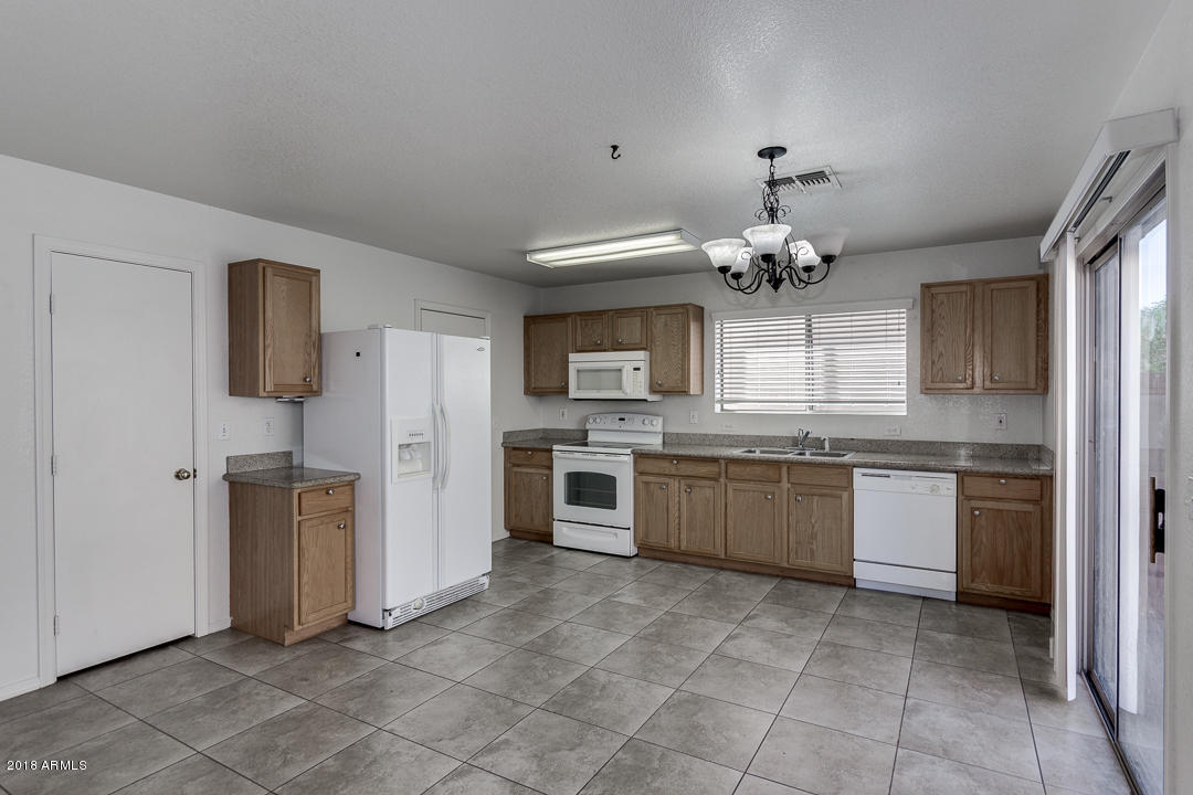3340 South Bowman Road Apache Junction, AZ 85119 - Photo 8 of 28 a large kitchen with a stove top oven a refrigerator and a sink