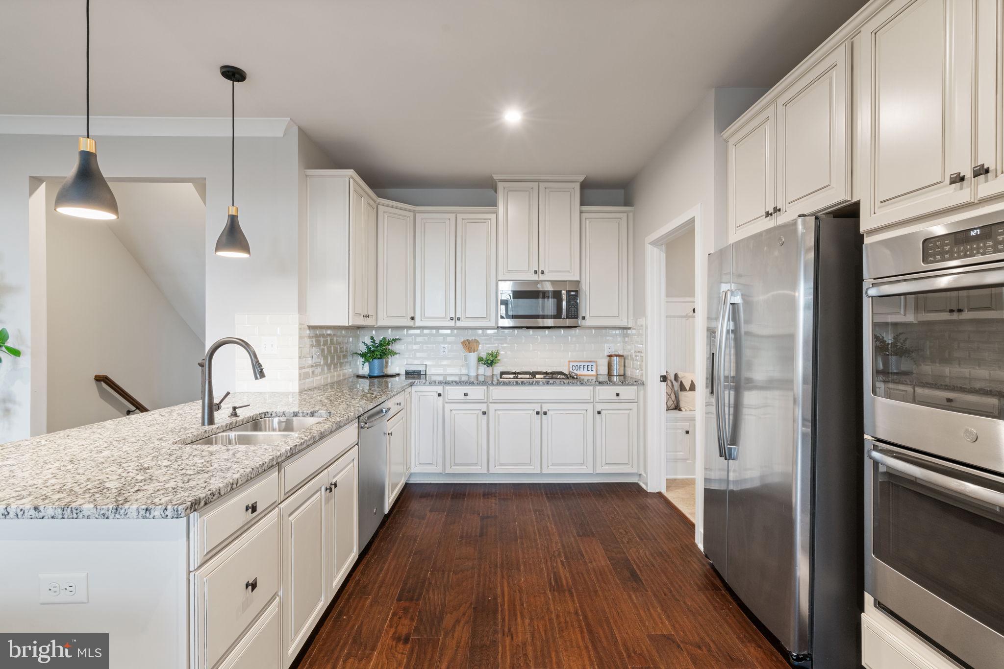 18180 Red Mulberry Road Dumfries, VA 22026 - Photo 12 of 87 a kitchen with kitchen island granite countertop appliances cabinets and a sink