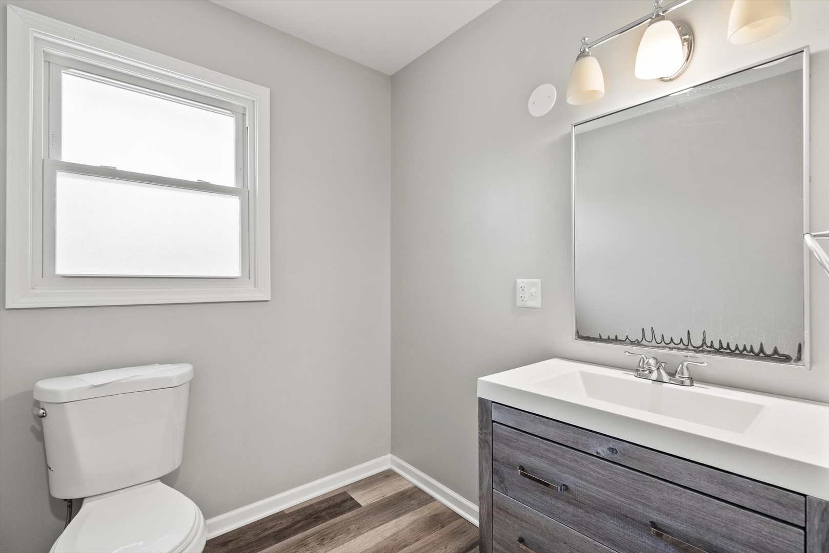 32W266 Glos Street Wayne, IL 60184 - Photo 10 of 24 a bathroom with a toilet a sink and a window