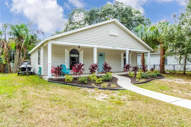 a view of a house with table and chairs in patio