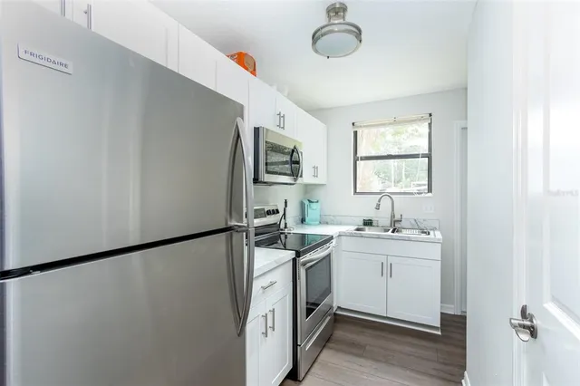 a kitchen with a sink a refrigerator and window