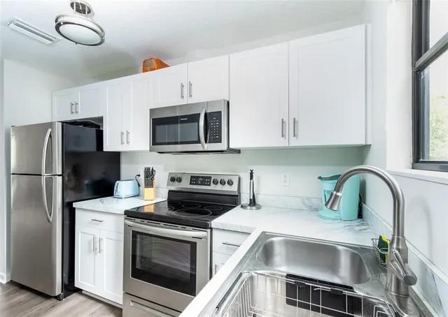 a kitchen with a sink cabinets and stainless steel appliances