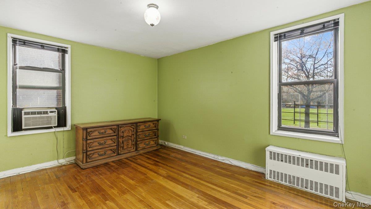 83-35 139th Street, Unit 1D Queens, NY 11435 - Photo 12 of 20 a view of an empty room with window and wooden floor