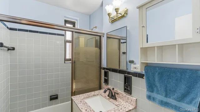a bathroom with a sink mirror and shower