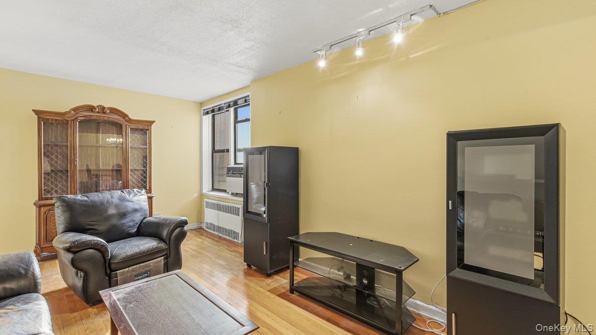 83-35 139th Street, Unit 1D Queens, NY 11435 - Photo 3 of 20 a living room with furniture a flat screen tv and a refrigerator