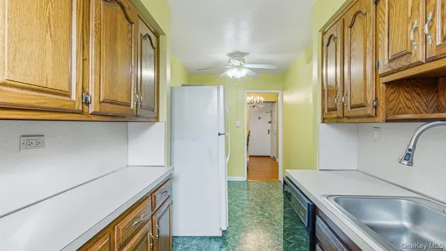 a kitchen with stainless steel appliances granite countertop a sink a stove and a refrigerator with wooden floor