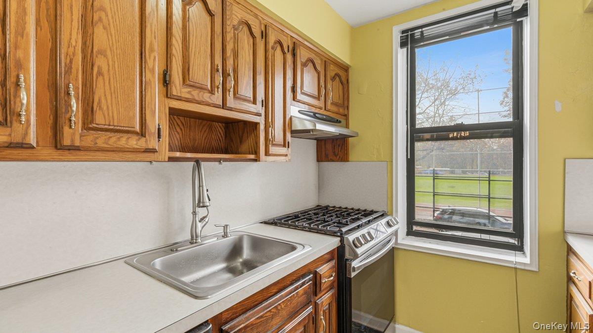83-35 139th Street, Unit 1D Queens, NY 11435 - Photo 9 of 20 a kitchen that has a sink and a stove with wooden floor