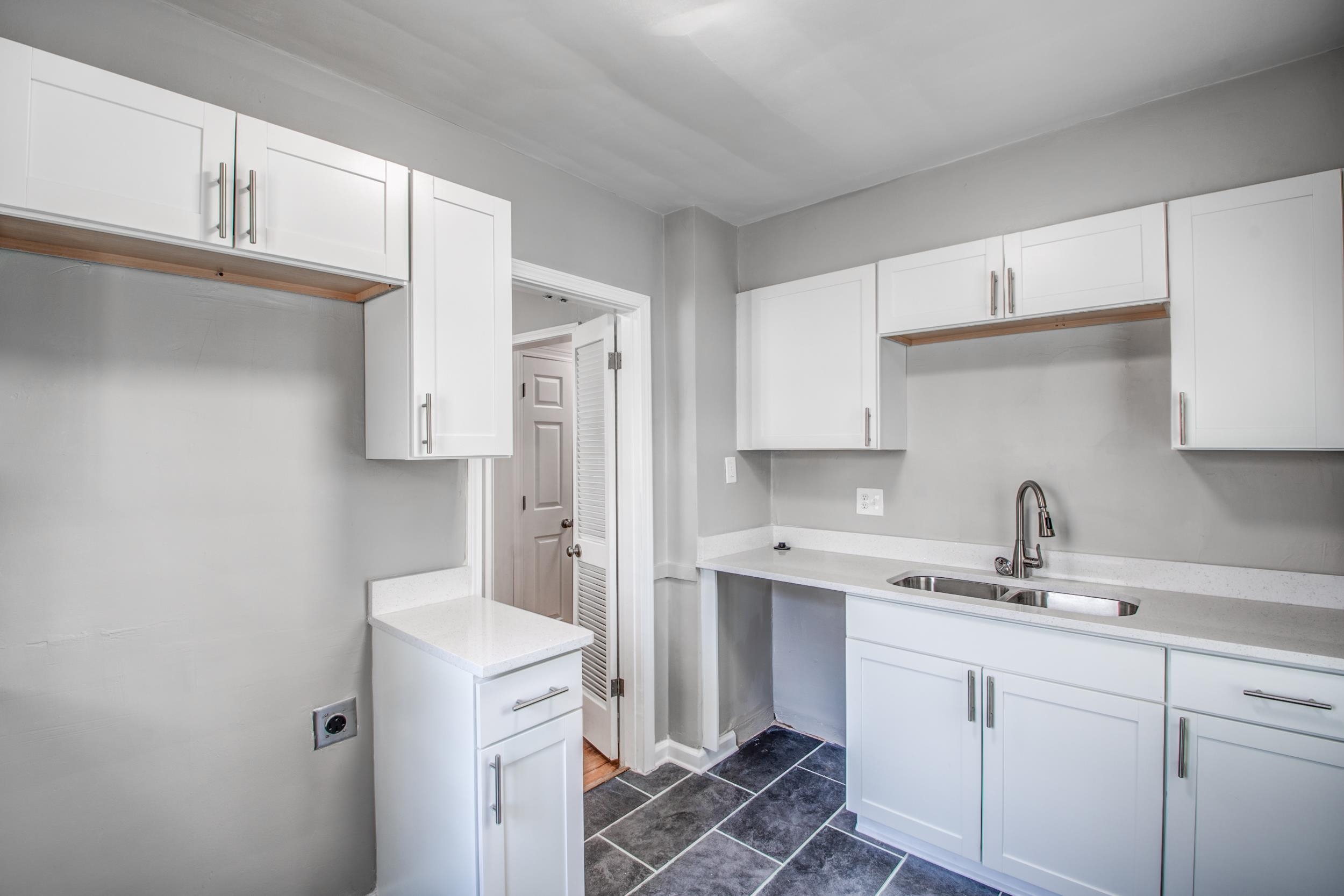 835 Watson Street Memphis, TN 38111 - Photo 14 of 24 Kitchen with white cabinets, dark tile patterned floors, and light stone countertops