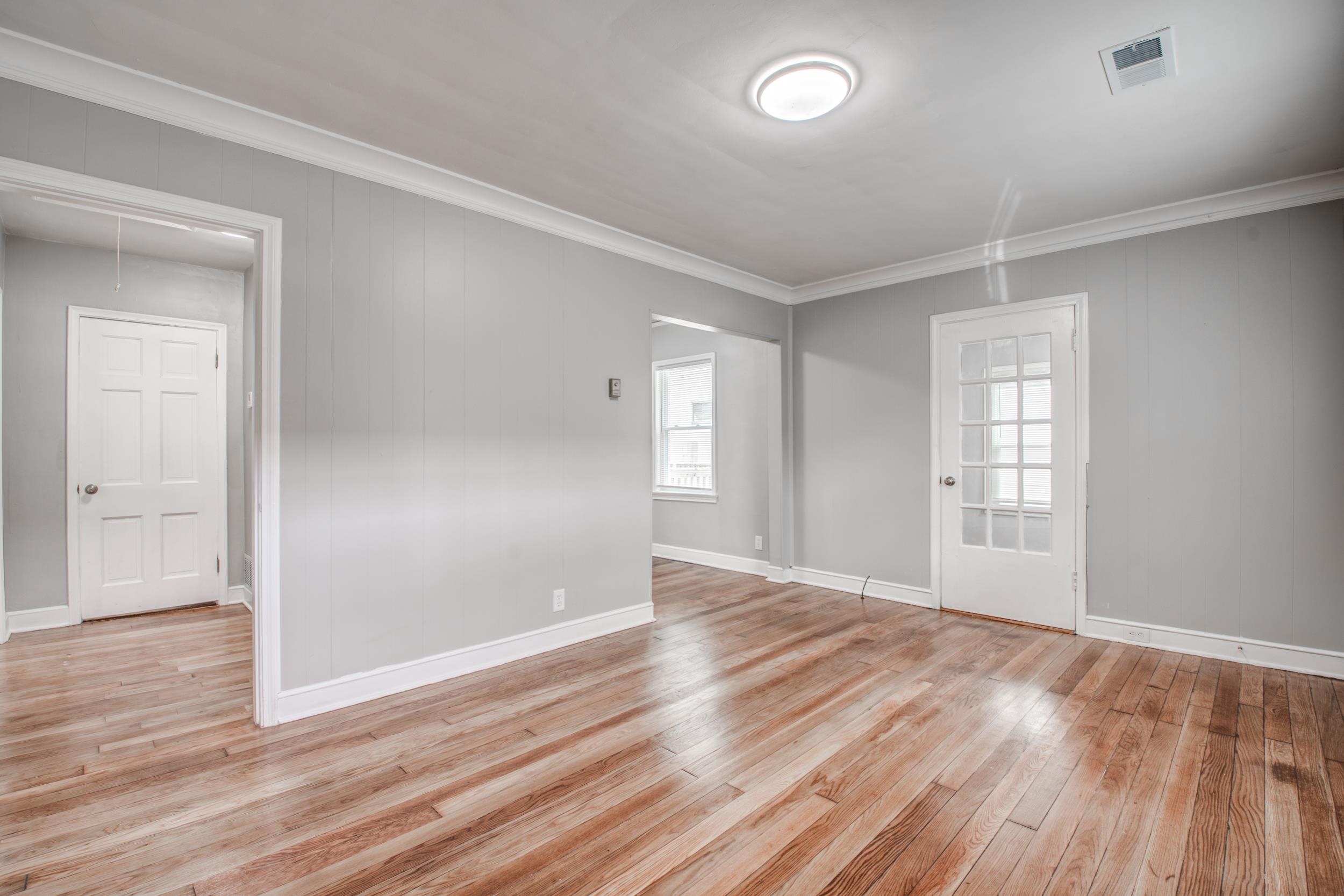 835 Watson Street Memphis, TN 38111 - Photo 6 of 24 Empty room featuring ornamental molding, light wood-style flooring, and wooden walls