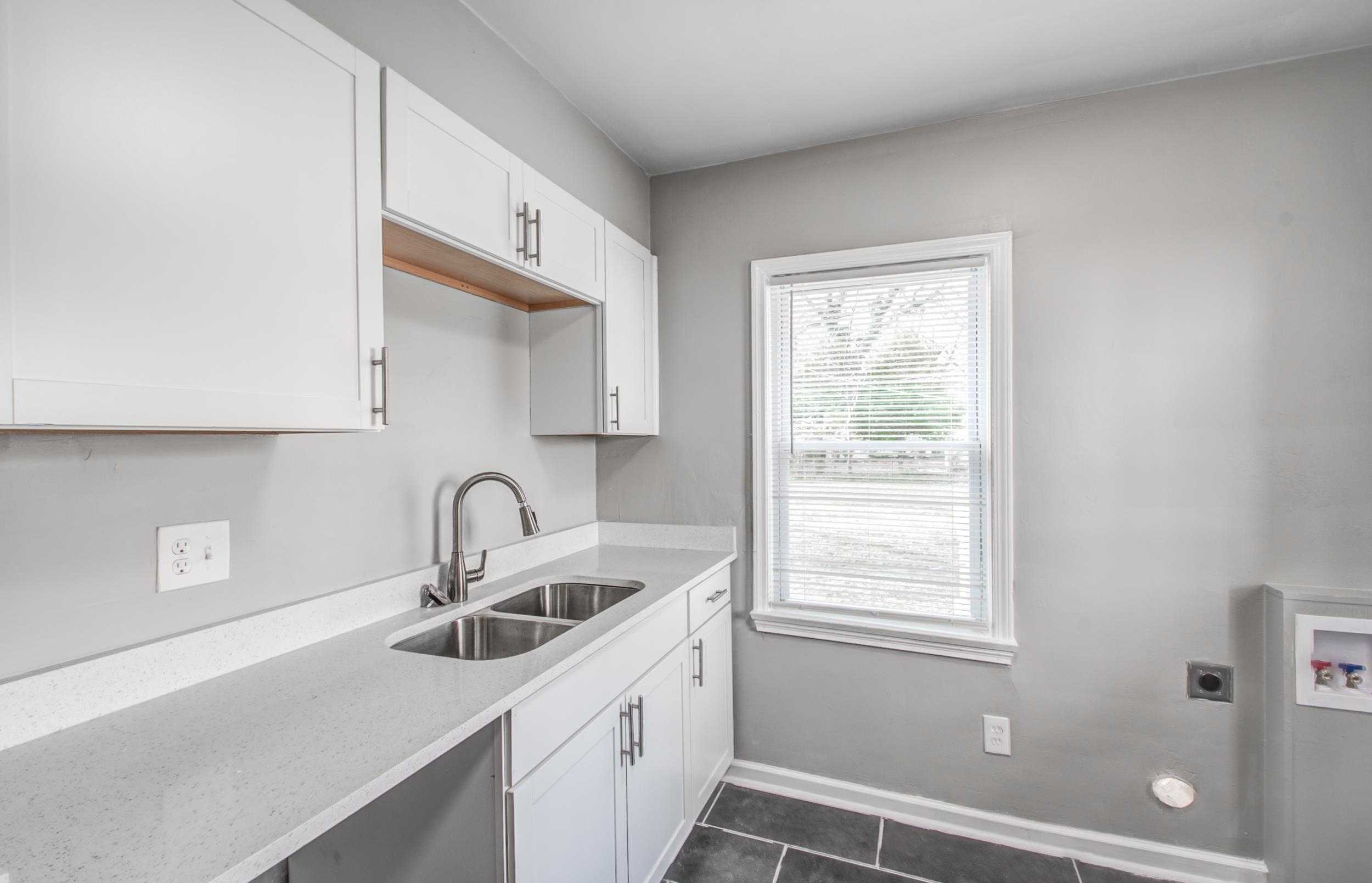 835 Watson Street Memphis, TN 38111 - Photo 10 of 24 Kitchen with white cabinetry, light stone countertops, and dark tile patterned flooring