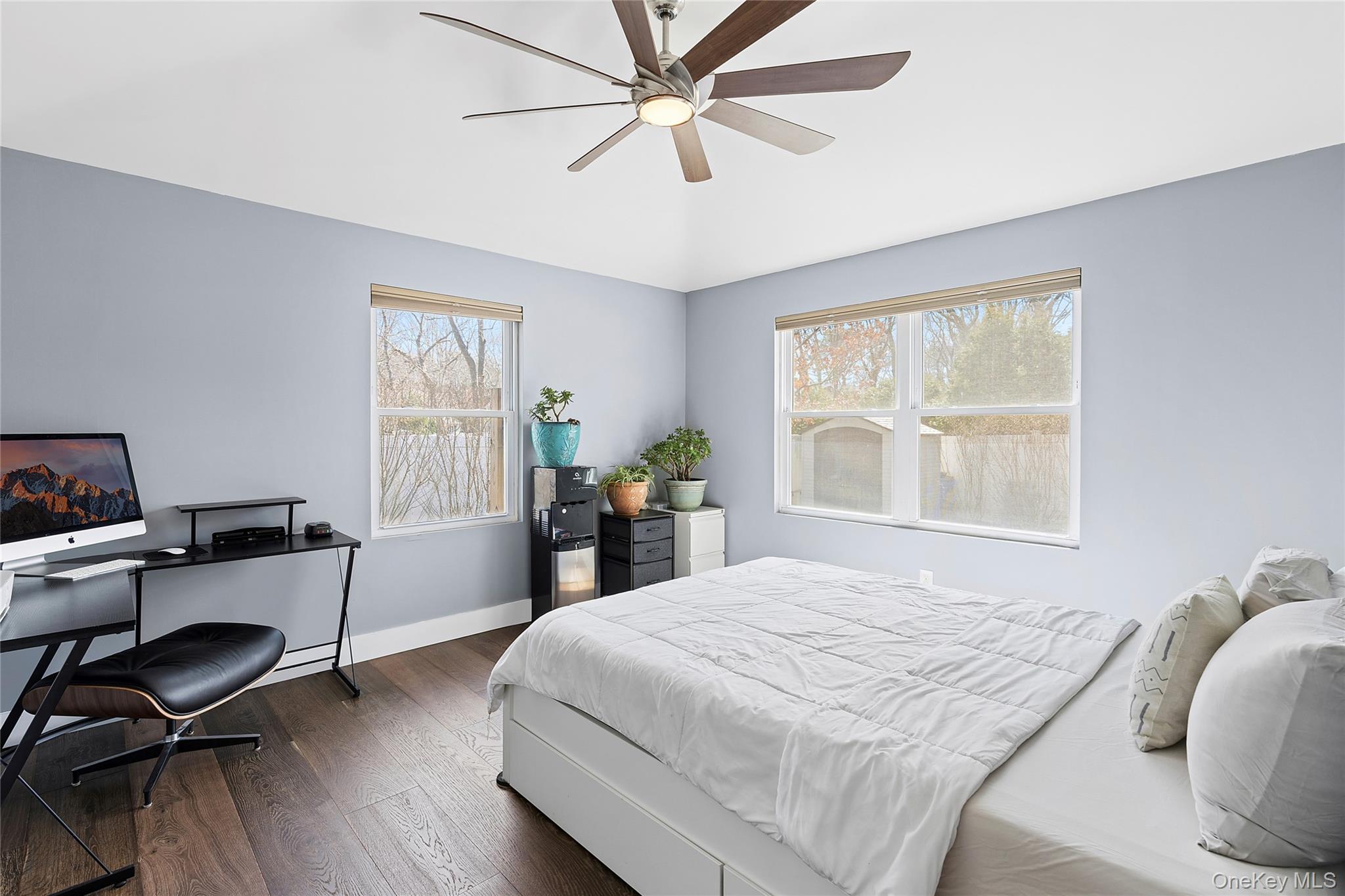 24 Woodridge Road Hampton Bays, NY 11946 - Photo 10 of 18 a bedroom with a bed a desk and chair with wooden floor