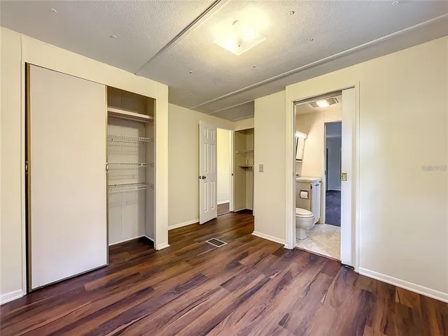 a view of a hallway with wooden floor and closet