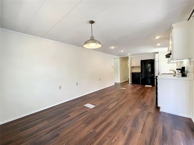 a kitchen with stainless steel appliances a refrigerator and wooden floor