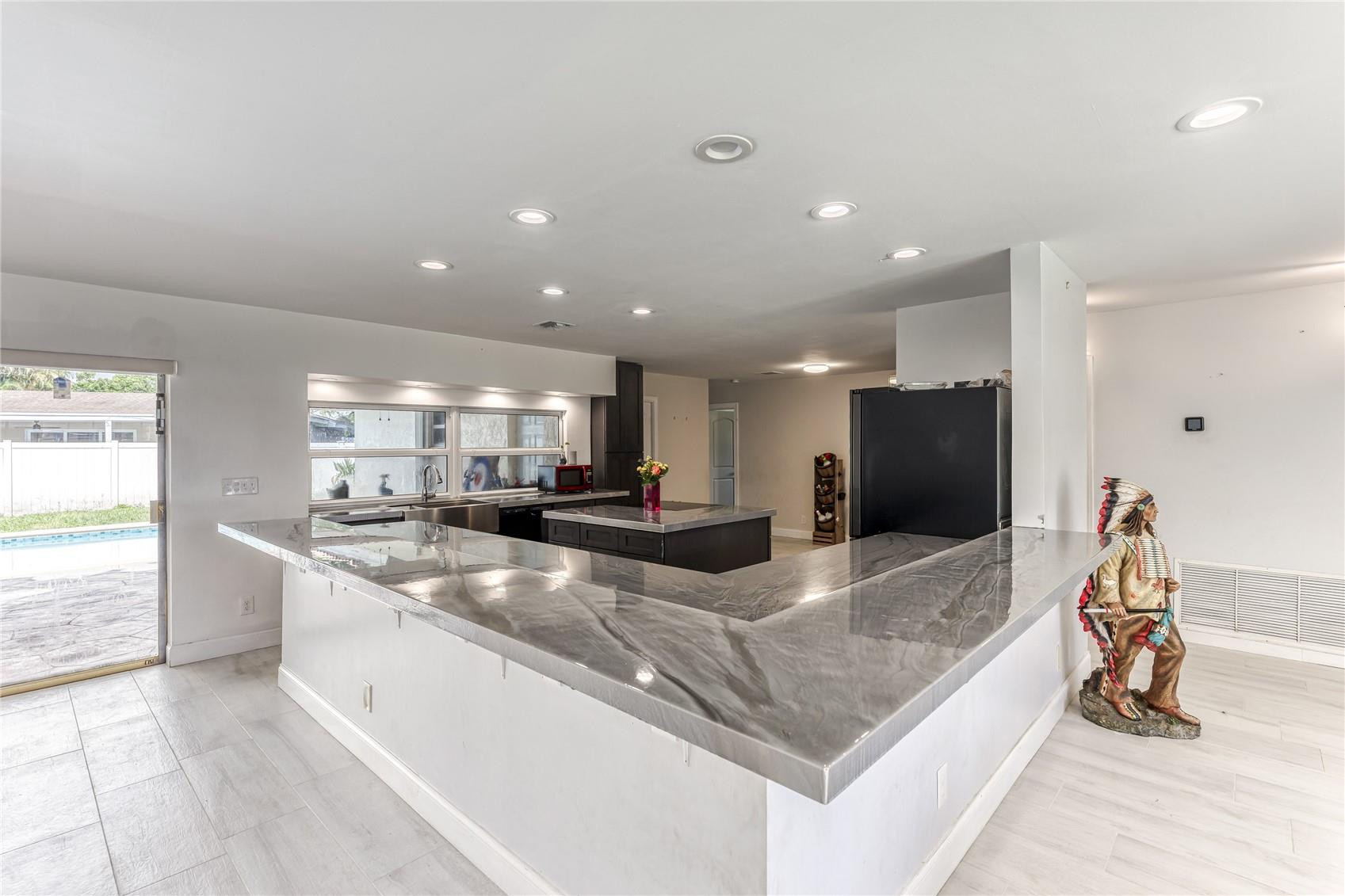 601 Southwest 8th Terrace Boca Raton, FL 33486 - Photo 5 of 47 a large white kitchen with a large window and stainless steel appliances