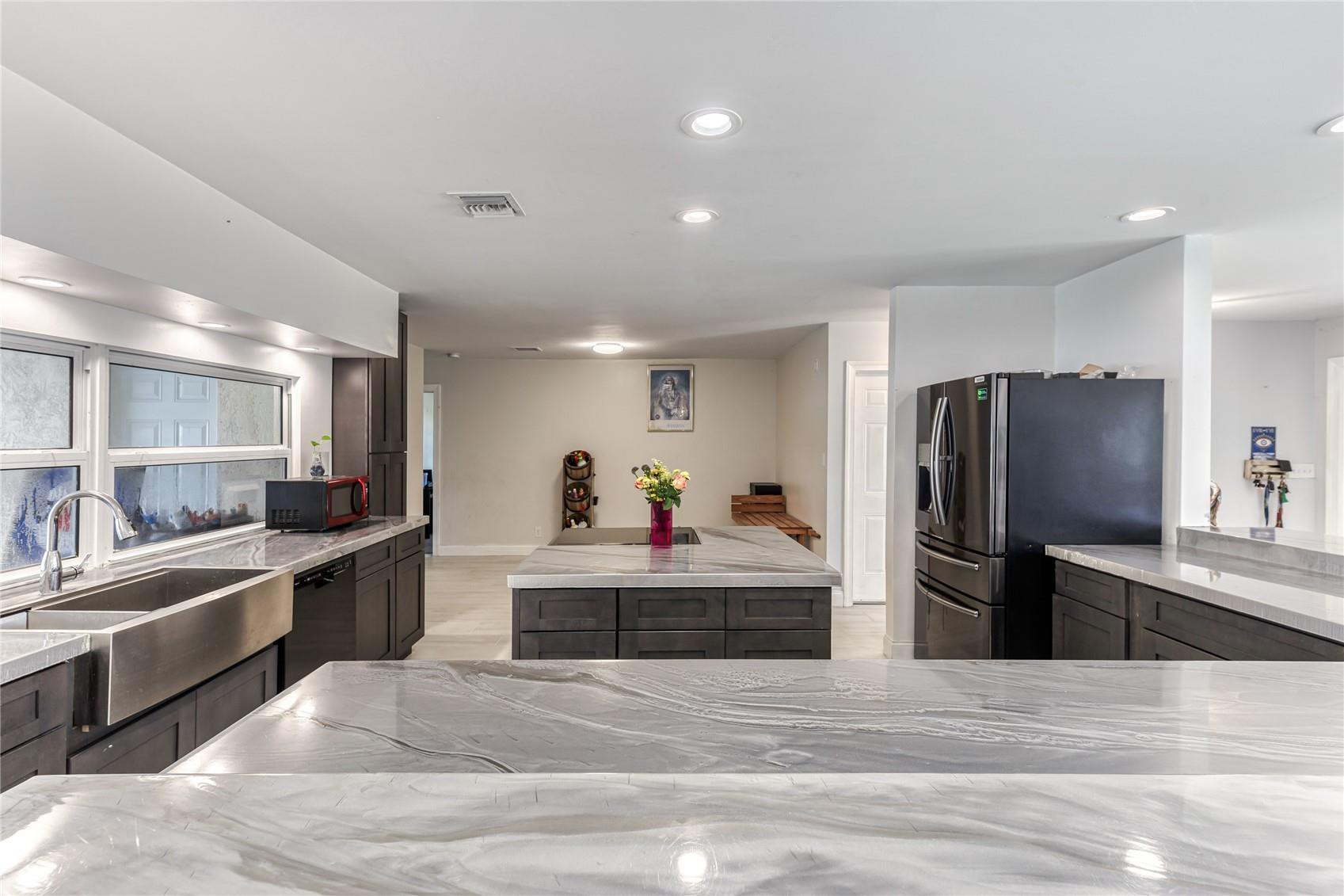 601 Southwest 8th Terrace Boca Raton, FL 33486 - Photo 8 of 47 a kitchen with stainless steel appliances kitchen island granite countertop a refrigerator and a stove top oven