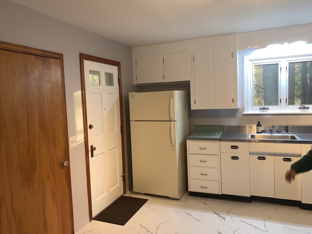 124 Brimfield Road Monson, MA 01057 - Photo 8 of 36 a kitchen with a refrigerator a sink and cabinets