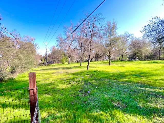 a view of a big yard with a house in the background