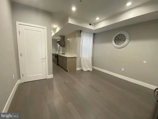 en empty room with stainless steel appliances wooden floor and view living room