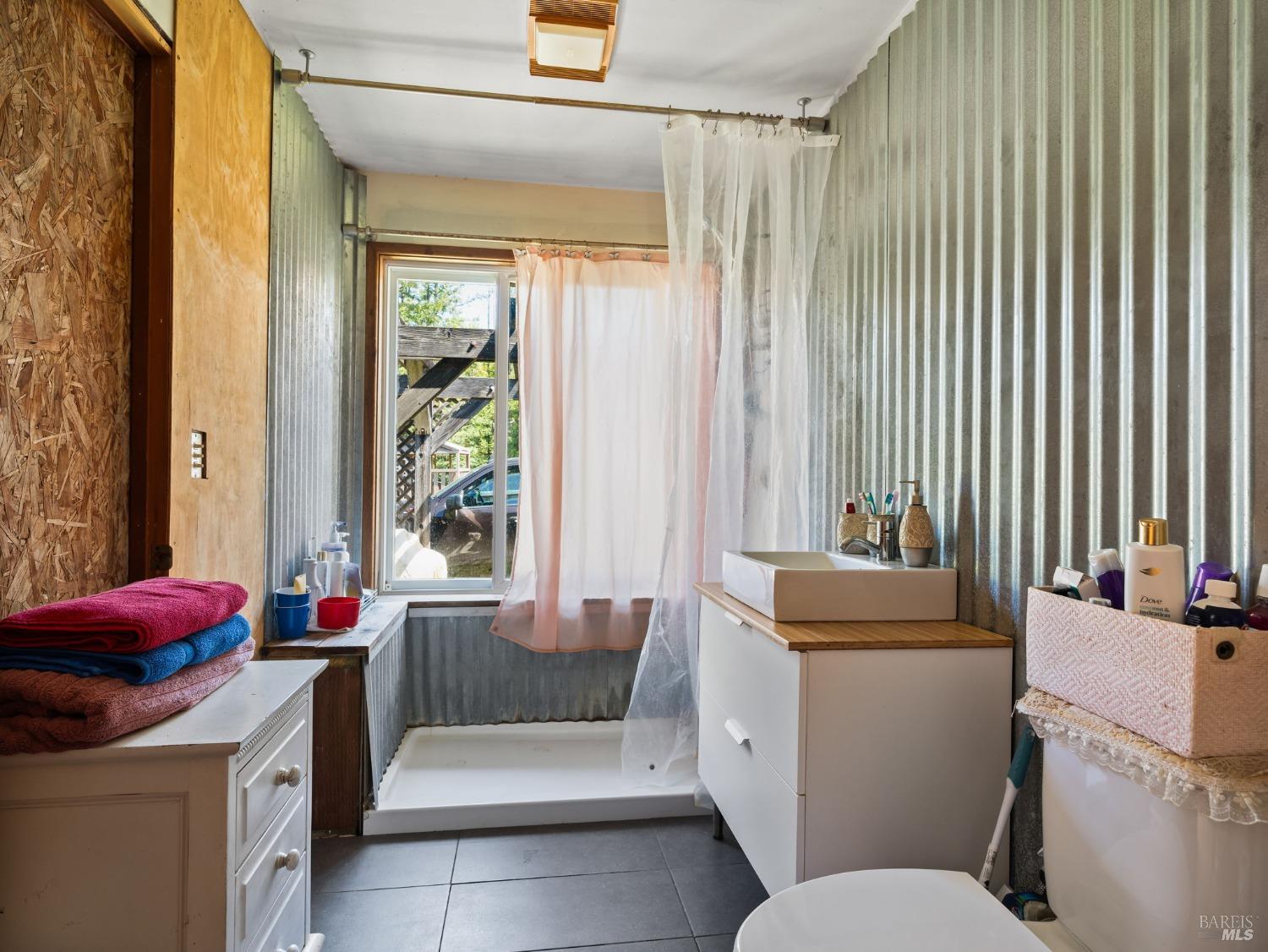 1550 Guntly Road Philo, CA 95466 - Photo 18 of 23 a living room with a couch and a dining table next to a window