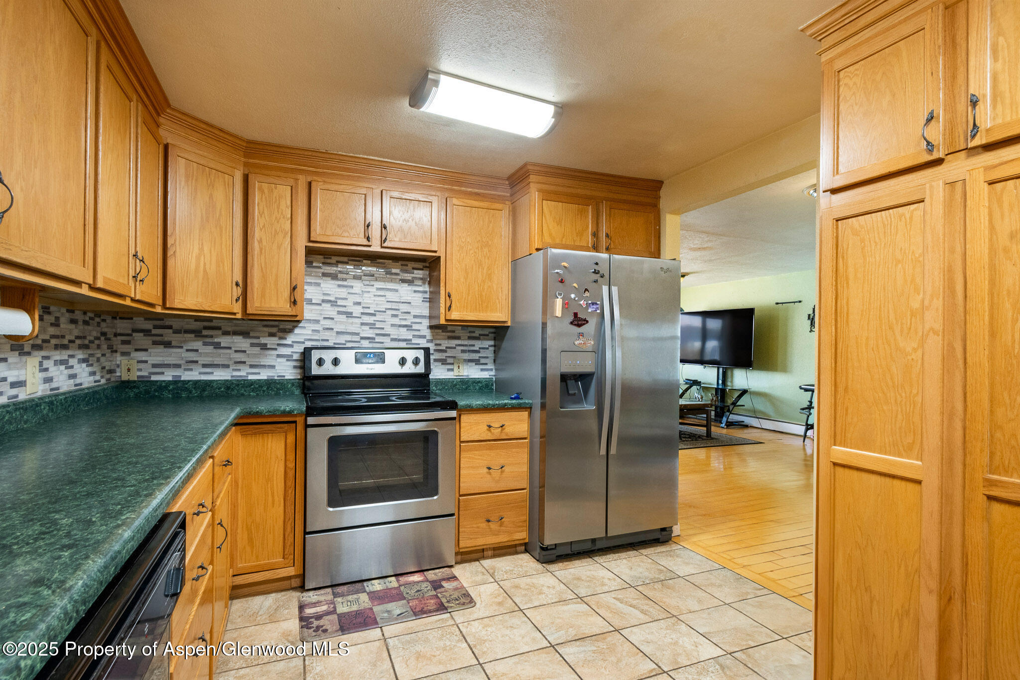 125 East 9th Street Rifle, CO 81650 - Photo 13 of 29 a kitchen with stainless steel appliances granite countertop a refrigerator a stove and a sink with wooden cabinets
