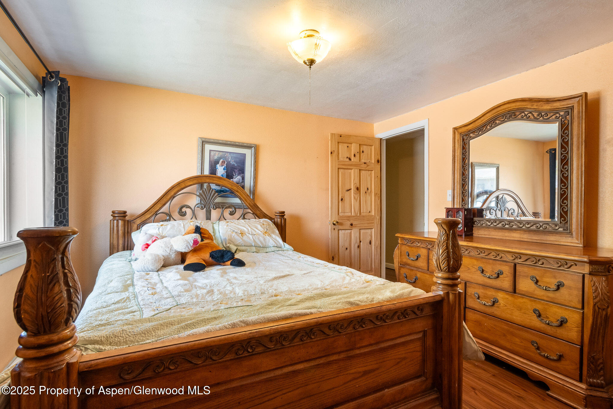 125 East 9th Street Rifle, CO 81650 - Photo 15 of 29 a bedroom with a bed and wooden floor