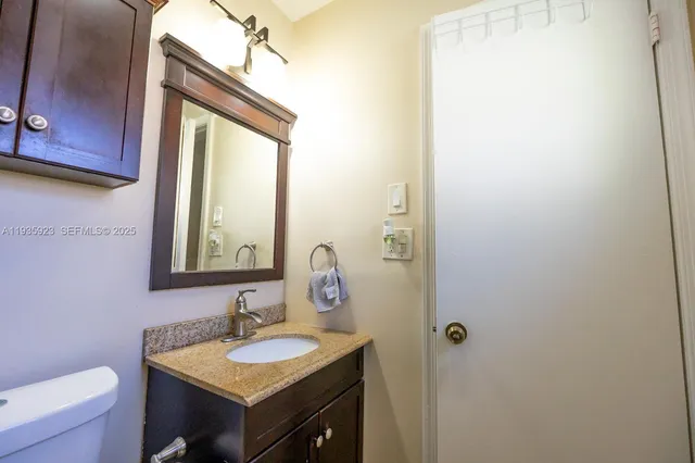 a bathroom with a granite countertop sink and a mirror