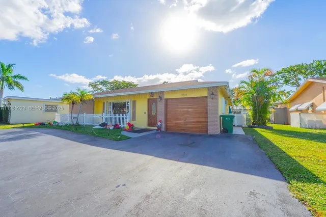 a view of a house with a yard and a garage