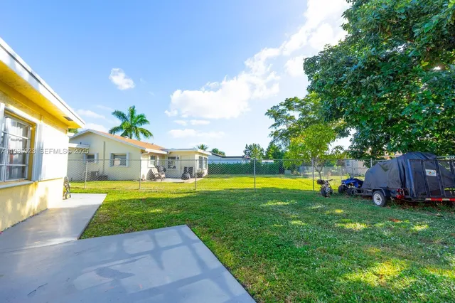 a view of a house with a swimming pool and a yard