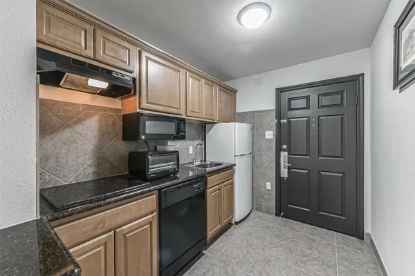 a kitchen with stainless steel appliances granite countertop a refrigerator and a stove